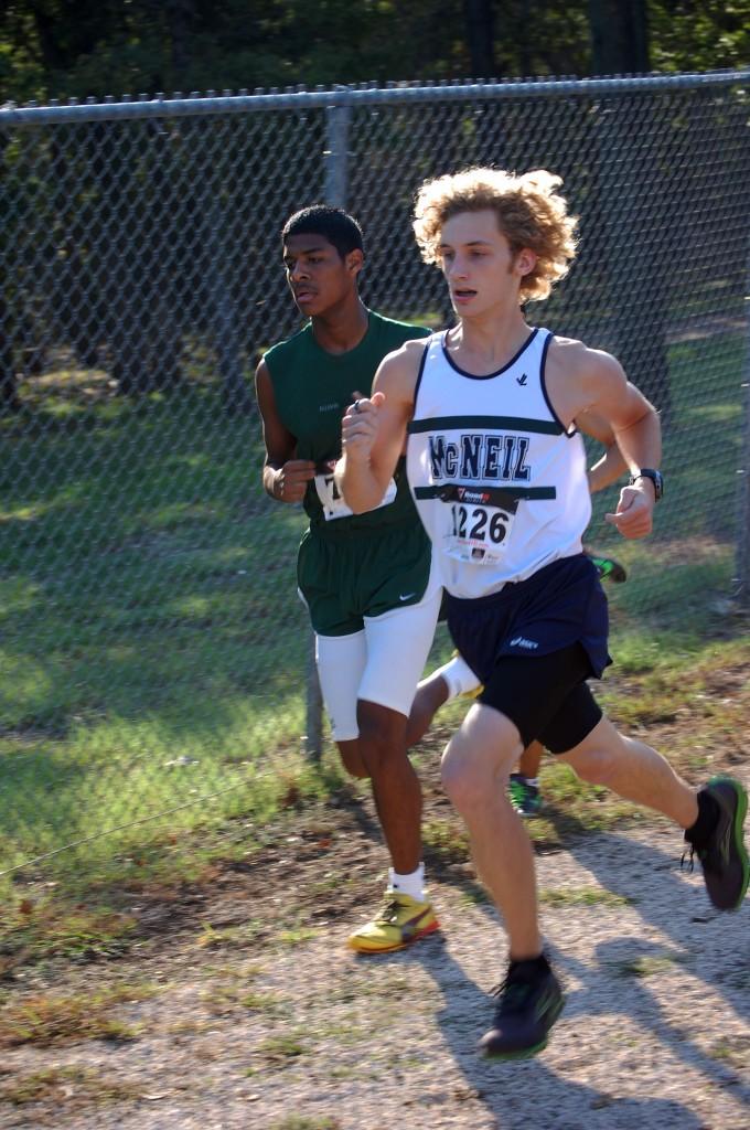 Ethan VanGorkem (12) is surging around the fence. The McNeil team went to achieve 6th place.  