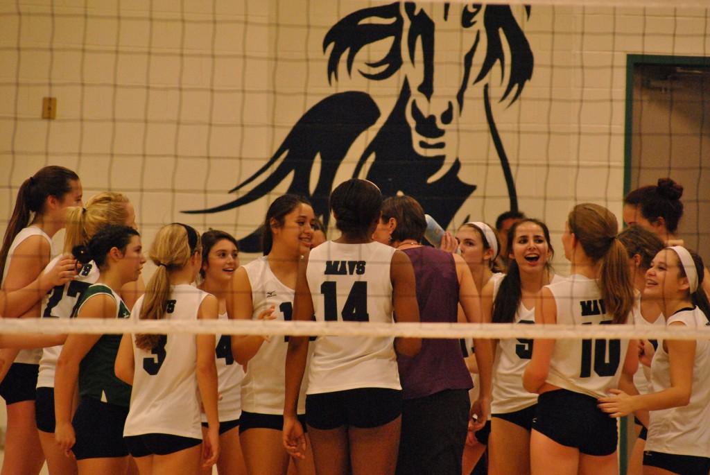 The Lady Maverick volleyball team huddles in a break between the sets. The girls encouraged each other and talked about the previous sets. 