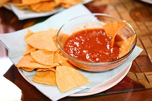 Salsa, a generally tomato based condiment that can be served with chips.