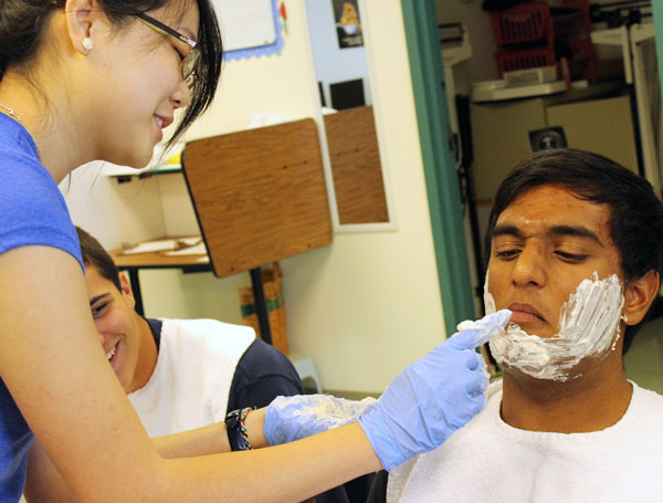 Close Shave: Practicing her shaving skills, junior Lilia Dinh applies shaving cream to junior Jeremy Matthews. The Certified Nursing Assistant class prepares students for the duties that come with the responsibilities of becoming a certified nurse. “It was nerve-wracking at first,” Dinh said. “But when I got the hang of it, it was easier and I only scratched him.