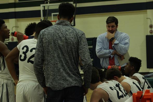 The Varsity basketball team regroups in a huddle during a time-out.