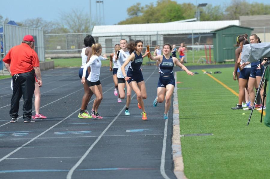 Sophomore Maddie Marrone hands off the baton to junior Larissa Herold in the 4x800 meter relay. The team took first place in the event.
