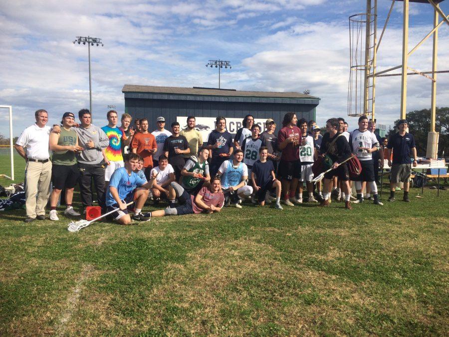 Lacrosse team members and alumni pose gather after the annual Alumni Game.