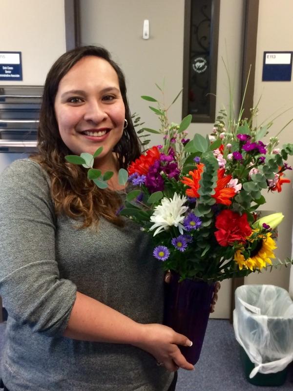Ruby Lozano smiles with her bouquet, delivered to her with her Paraprofessional of the Year award.