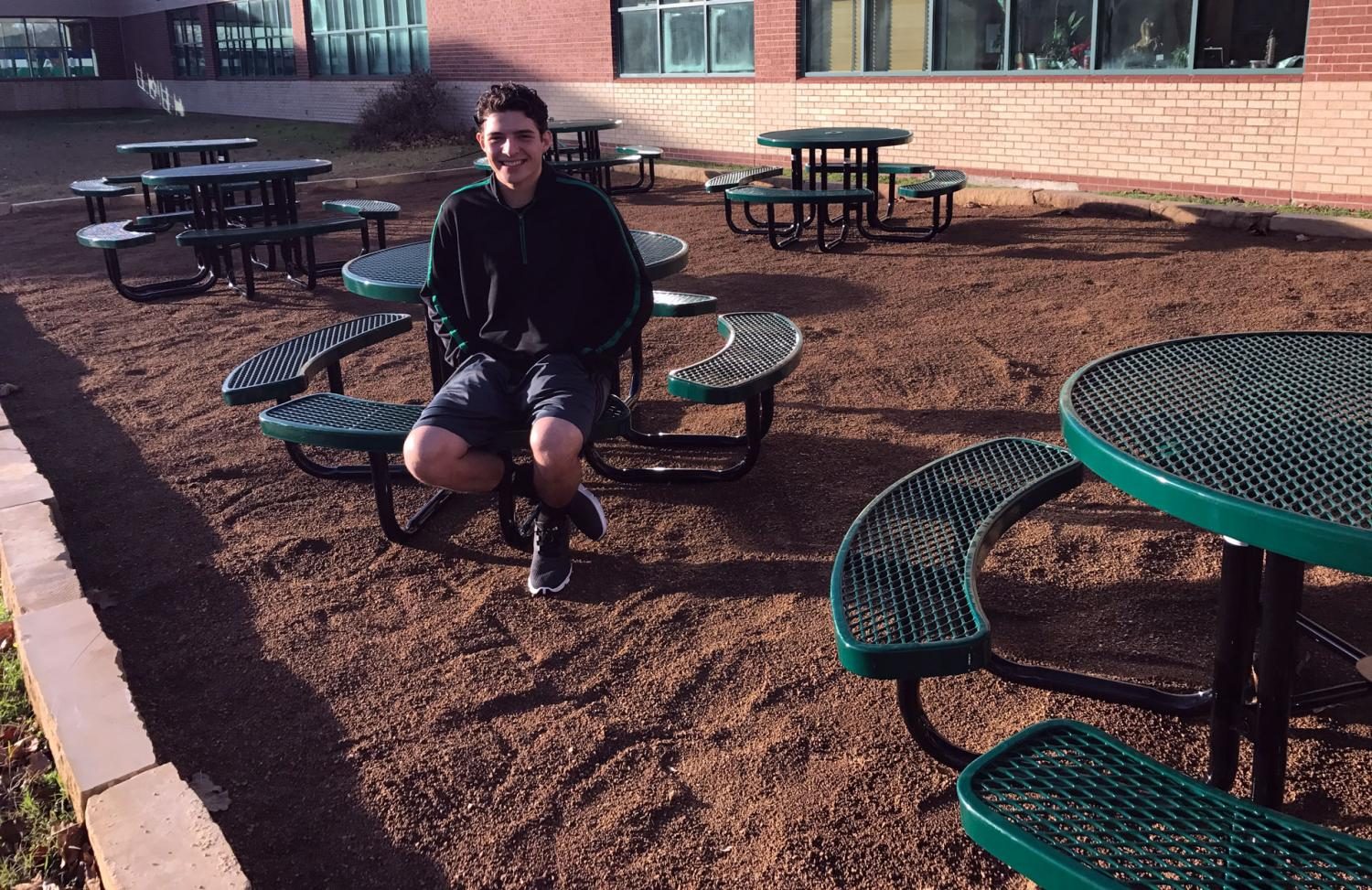 After completing the outdoor classroom in the center courtyard, senior Luke Guajardo tries out the benches. As his Eagle Scout project, Guajardo partnered with Environmental Science teacher Tina Vick, who had the the vision to create an alternate learning environment for all courses to use.