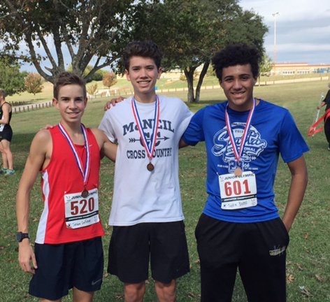 Justin Bozell, Alec McAndrew, and Gabe Alvarado poser during a meet.