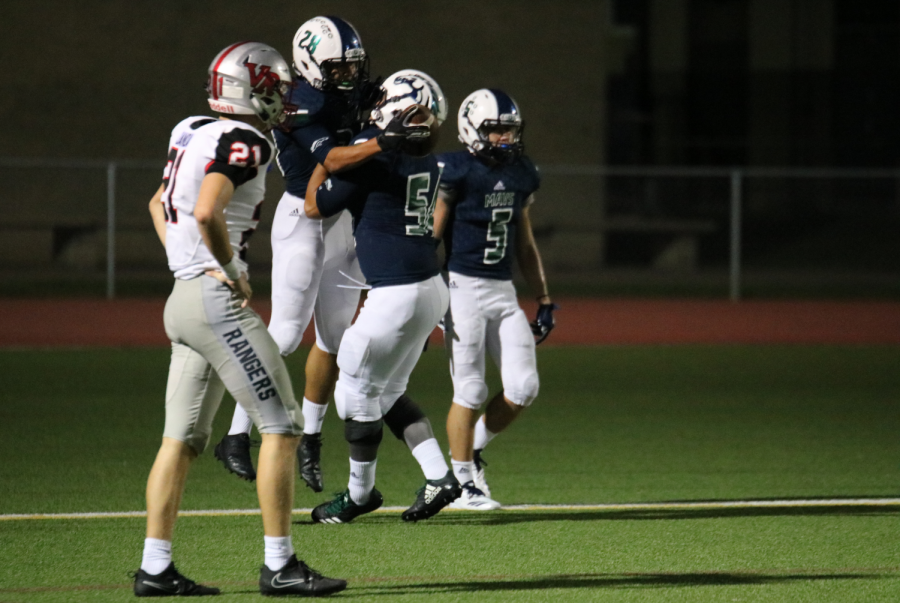 After punching in a touchdown, junior running back Winston Hutchison (#28) celebrates with senior offensive lineman Deinkhanh Tran (#54) in the endzone. The Mavs clinched their first district win over the Vista Ridge Rangers 49-21 at Dragon Stadium Sept. 14.