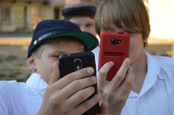 Two kids using their phones.