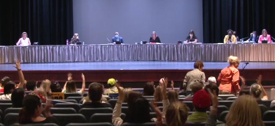 At the request of Board President Weir, audience members use jazz hands to silently applaud a speaker.