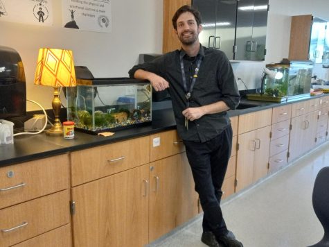 Aquatic science teacher Mark Romano poses beside the student-run tank filled with Neon-Tetras. 

“It’s important to have [animals in the aquatic science classroom] because students are probably asking themselves ‘When am I going to use this in life?’. Well, they’re making real life happen right here in the classroom by doing the trout program, learning how to start a tank or by just going over there and appreciating nature in its little boxed form here.” 