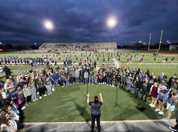 McNeil+and+middle+school+choir+students+sing+the+US+National+Anthem+at+the+Oct.+28+varsity+football+game+as+part+of+Choir+Middle+School+Night.+During+the+event%2C+choir+students+encouraged+middle+schoolers+to+join+the+organization+during+their+first+year+of+high+school+and+socialized+with+one+another.+%0A%0A%E2%80%9CMy+favorite+part+of+Middle+School+Night+was+just+seeing+the+future+choir+students+of+McNeil+and+knowing+that+the+program+will+be+fantastic+with+them%2C%E2%80%9D+senior+Class+Captain+and+Secretary+Elizabeth+Severinson+said.+%E2%80%9CSinging+together+and+becoming+proud+of+what+you%E2%80%99re+creating+is+the+most+rewarding+experience.%E2%80%9D+
