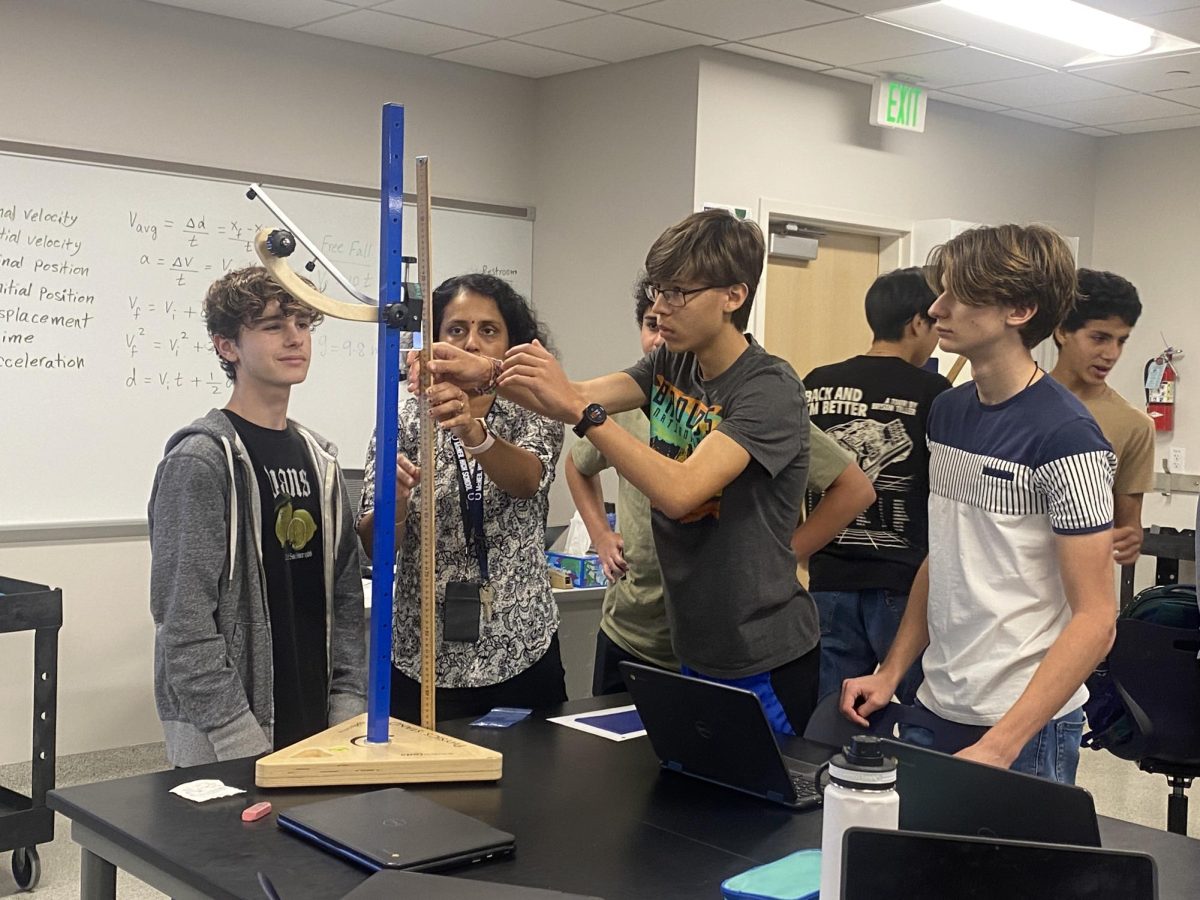 During a Projectile Motion lab for AP Physics, teacher Akshara Sudhakaran helps Juniors Harvey Flynn, Yasser El Anssari, Luca Uritu, Owen Rhea and Timothy Li measure the height of the launch ramp.