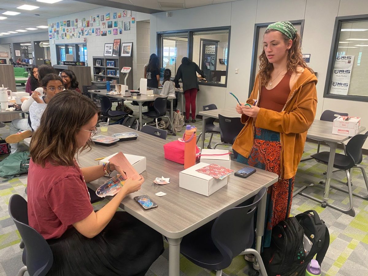 While creating their dioramas senior Maxfield Rotches is making string lights out of pipe cleaners while senior Lila Brown is tearing part of an old magazine to decorate her diorama with.