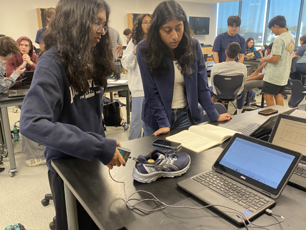 
Junior Rachel Abraham and junior Janani Pragalbha pulling the shoe with force sensor connected to their computer as it draws the graph, which they use to find kinetic and static forces.