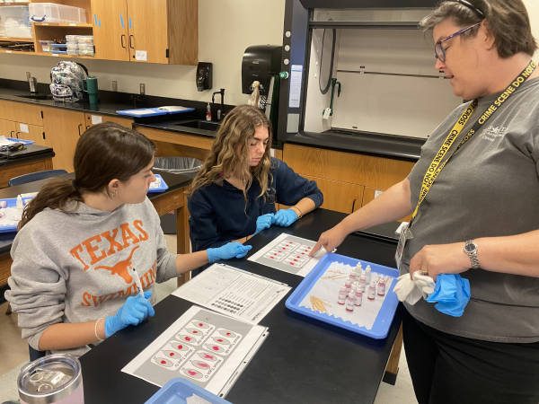 Forensics Teacher Carol Seng explaining to senior Tigerlily Broomfield and senior Megan Chandonia how to tell the difference between different blood types.