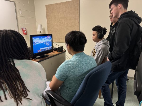 Members of the esports Super Smash Bros team watch their teammates compete for a spot in  tournament's starting line up.