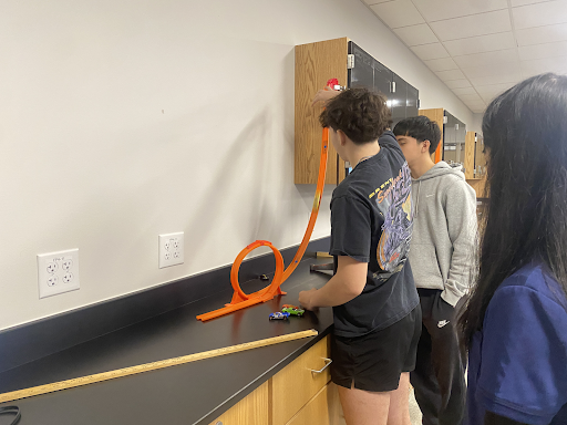 
Junior Megan Nguyen, senior Arturo Ramos and senior Pedro Vianna drop a car down a track during the lab.
