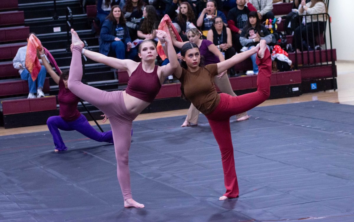 Freshman Katie Reed and junior Sophia Ball pose at the end of the winterguard show.