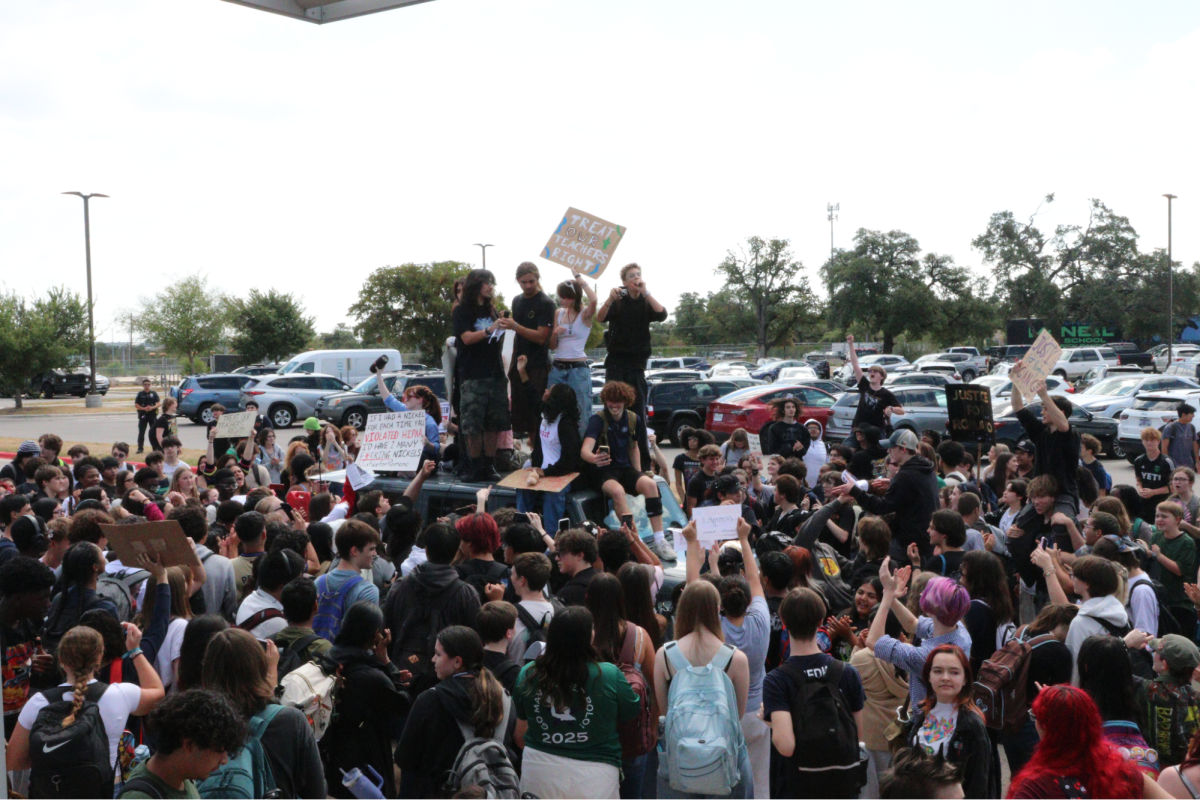Students assemble during a walkout taking place in the front of the school building Sep. 26