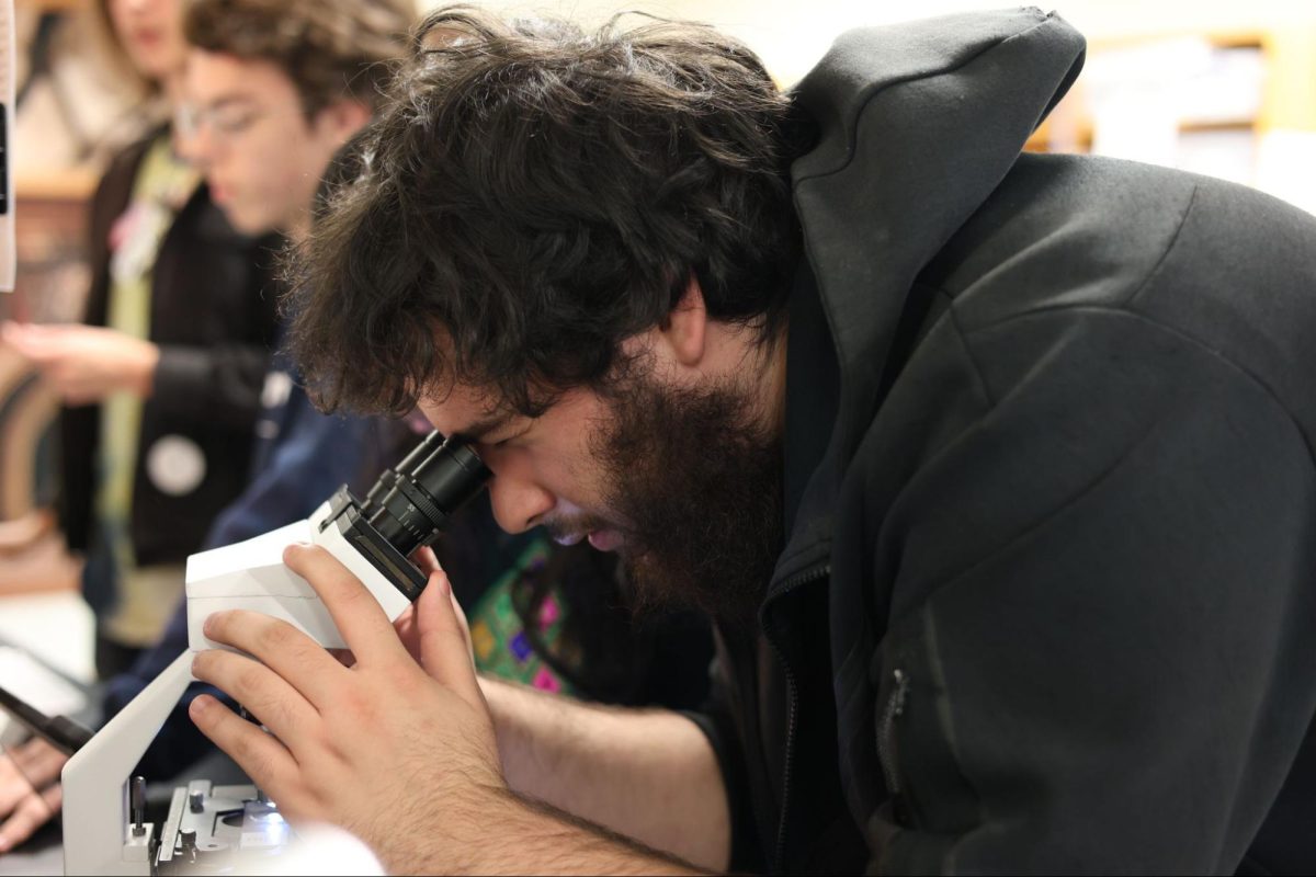 Senior Matthew Amador, looking into a microscope to identify fibers.
