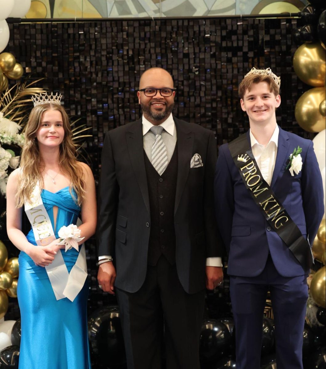 2025 Prom King Will Buchanan and Queen Maxine Olson pose with Lead Principal Dr. Mack Eagleton after celebrating their wins.