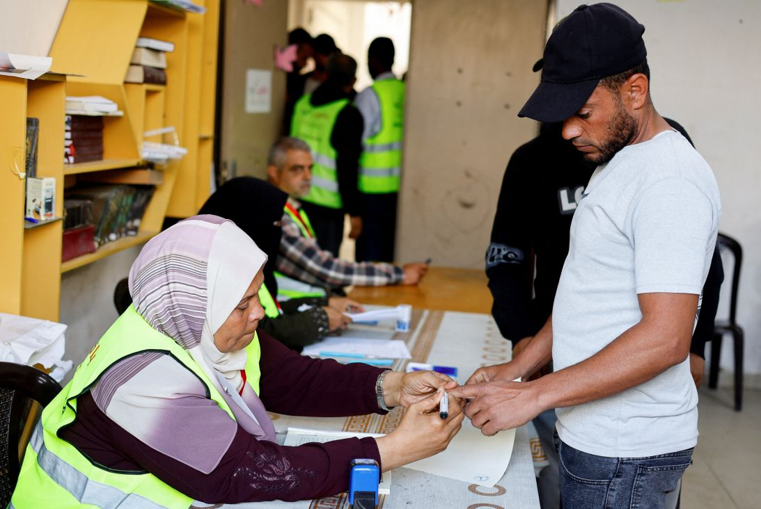 Polling official using ink to mark the finger of a Palestinian voter at the Deir al-Balah local elections, in central Gaza. Photo Courtesy of CNN World / Mahmoud Issa (Reuters)